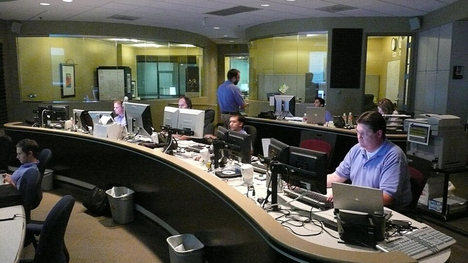 Network operations center with monitoring desks, representing unified governance across AI workspaces