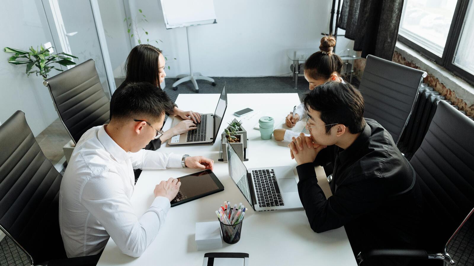 Team working around laptops in a meeting room, used for the shadow AI usage article